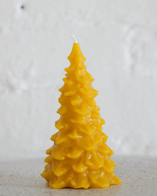 Beeswax candle shaped like a Christmas tree on a white background