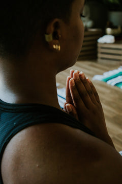 Person in a yoga class with eyes closed and hands at heart center.
