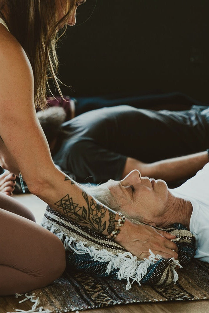 yoga teacher adjusting props of a student